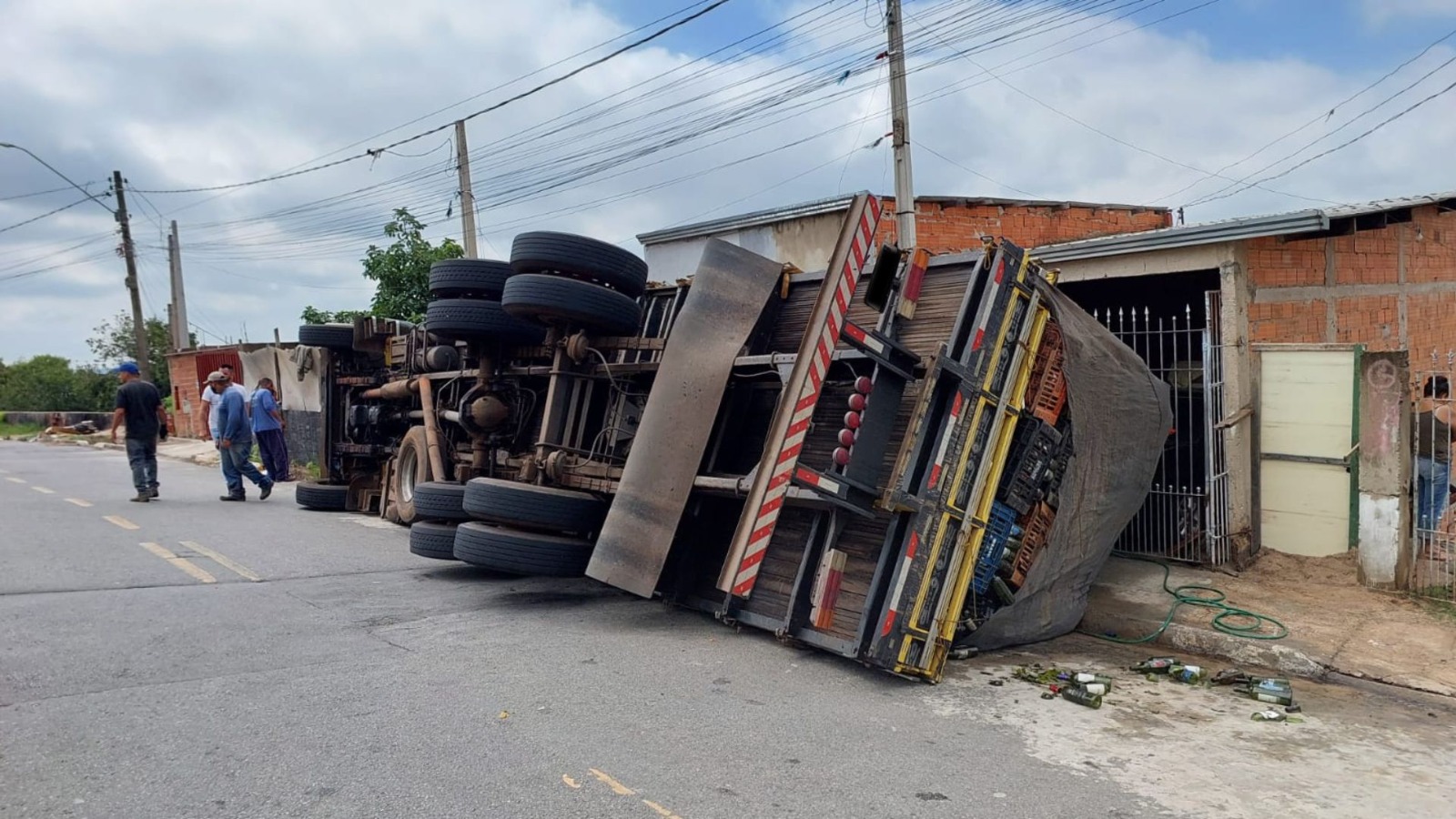 Caminhão carregado com garrafas tomba e assusta moradores