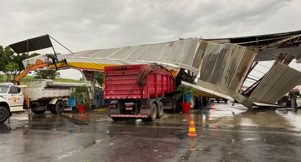 Chuva derruba cobertura de posto, árvores e causa alagamentos na região